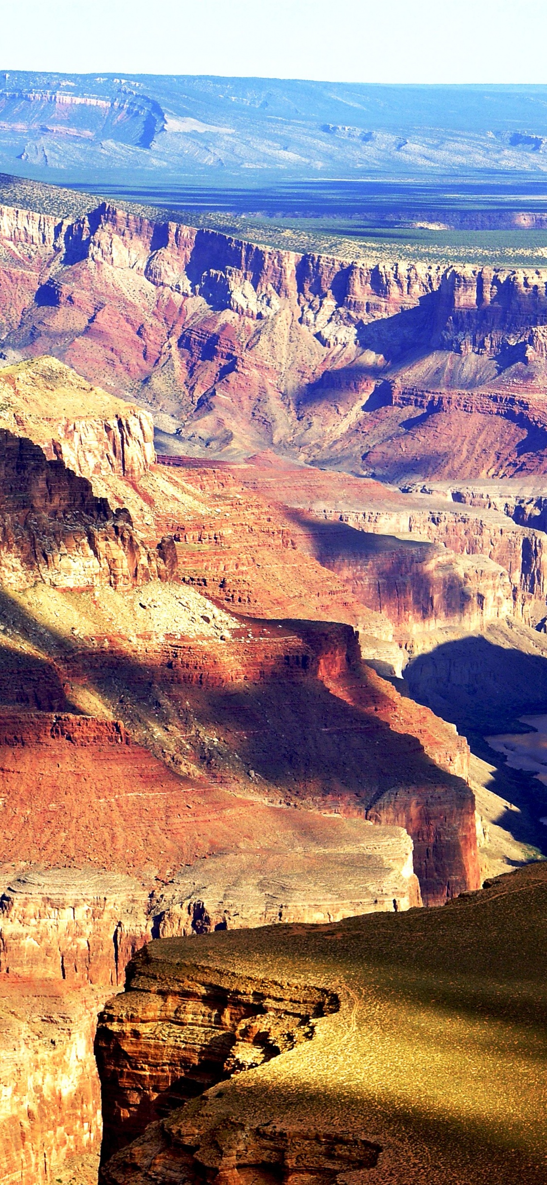 Brown Rocky Mountain Under Blue Sky During Daytime. Wallpaper in 1125x2436 Resolution