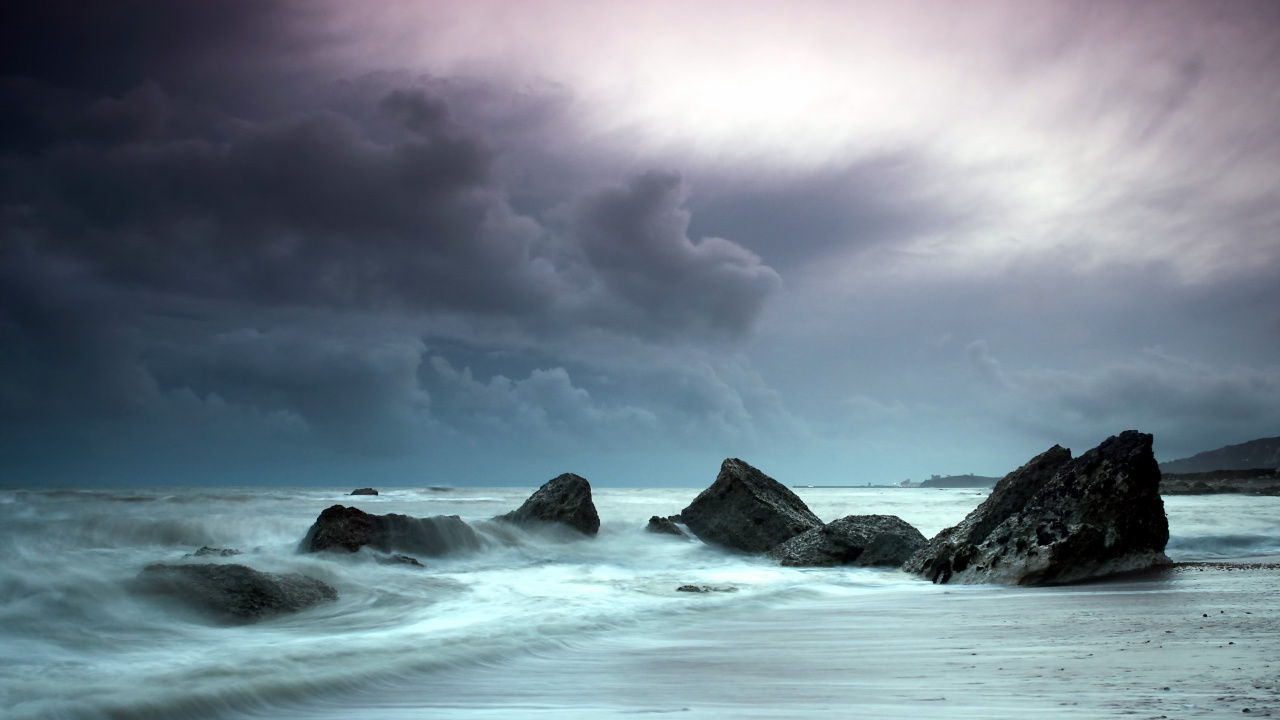 Olas Del Océano Rompiendo Contra Las Rocas Bajo el Cielo Nublado. Wallpaper in 1280x720 Resolution