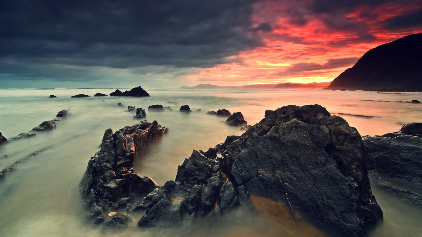 Rocky Shore Under Cloudy Sky During Daytime. Wallpaper in 1366x768 Resolution
