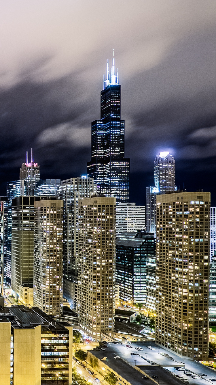 Ciudad Con Edificios de Gran Altura Bajo Nubes Grises Durante la Noche. Wallpaper in 750x1334 Resolution