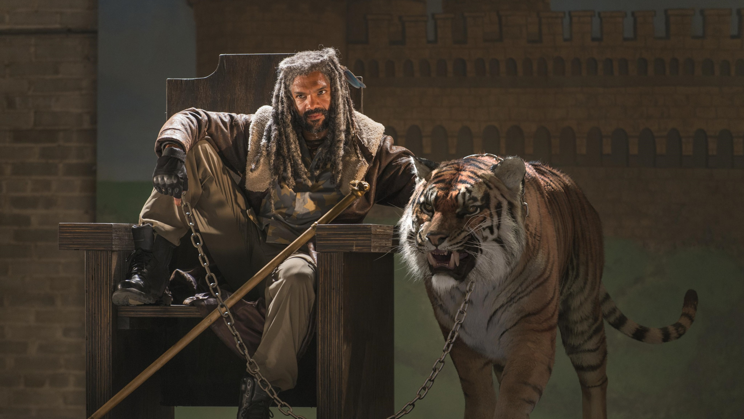 Man in Black and White Jacket Holding Brown Wooden Stick Beside White Tiger. Wallpaper in 2560x1440 Resolution