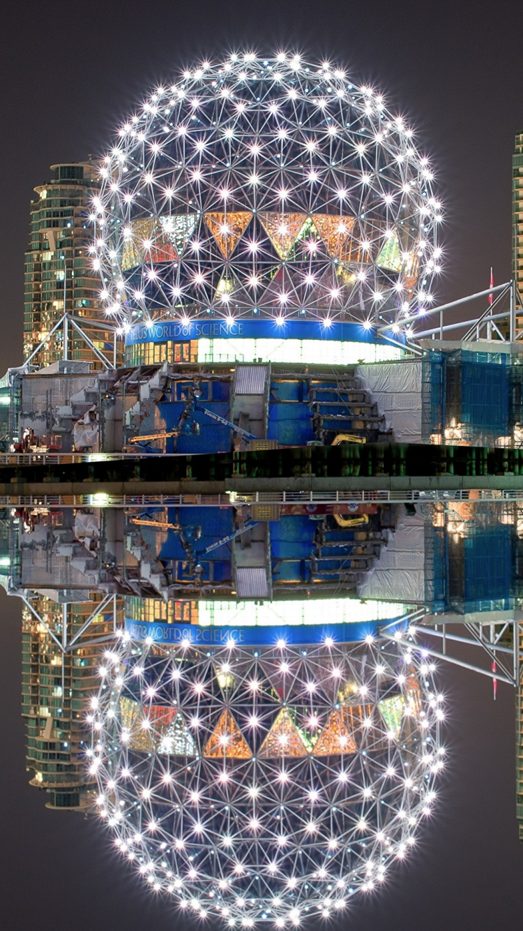 Blue and White Lighted Building Near Body of Water During Night Time. Wallpaper in 750x1334 Resolution