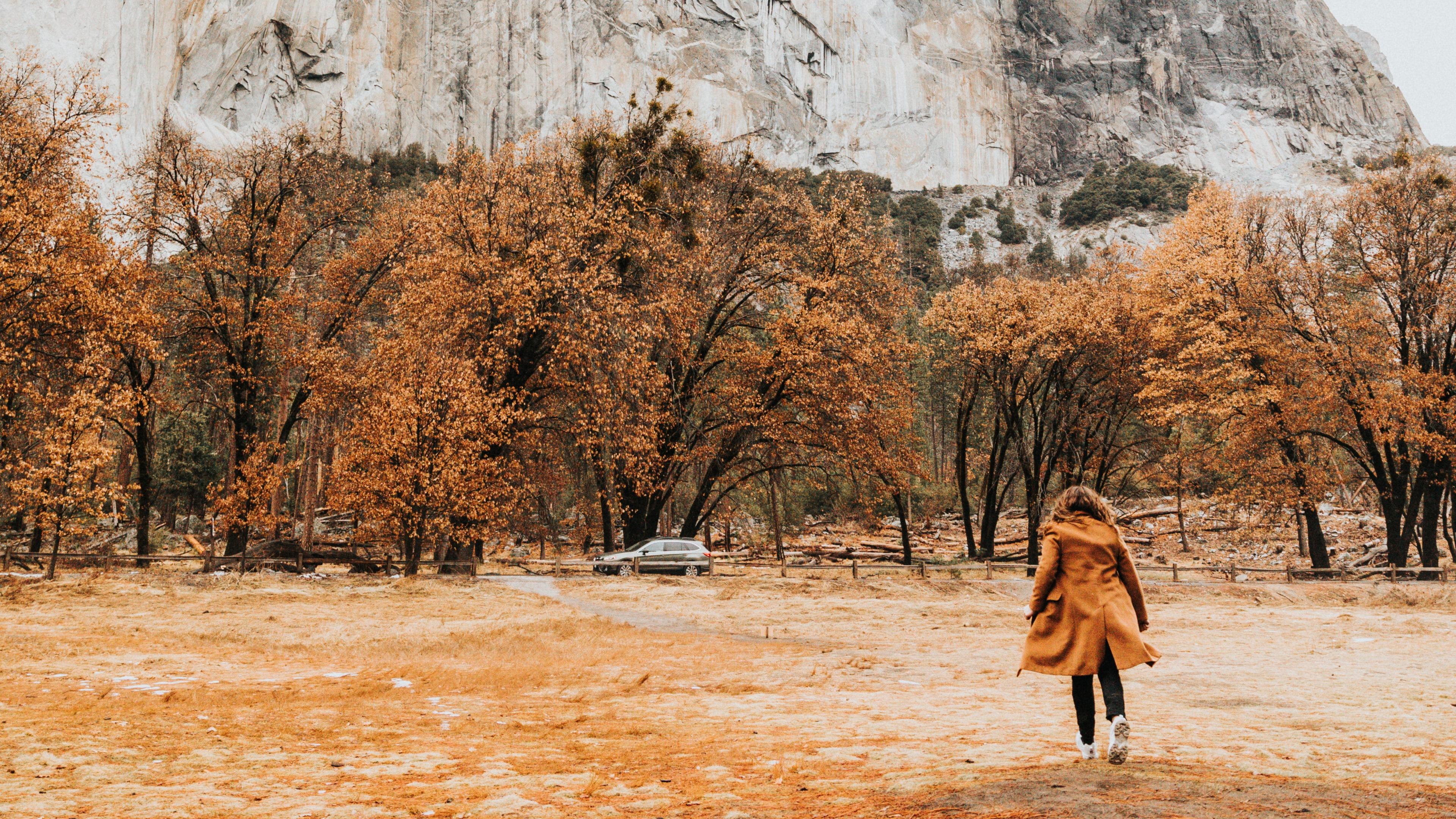 Person in Brown Coat Walking on Brown Field Near Gray Rock Mountain During Daytime. Wallpaper in 3840x2160 Resolution