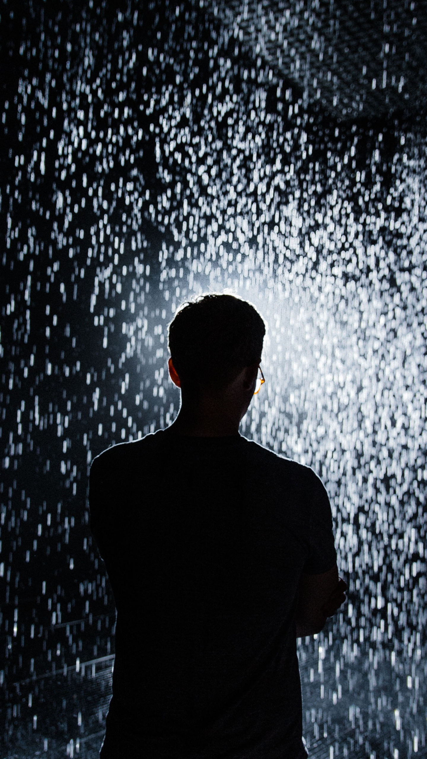 Man in Black Shirt Standing in Front of Water Splash. Wallpaper in 1440x2560 Resolution