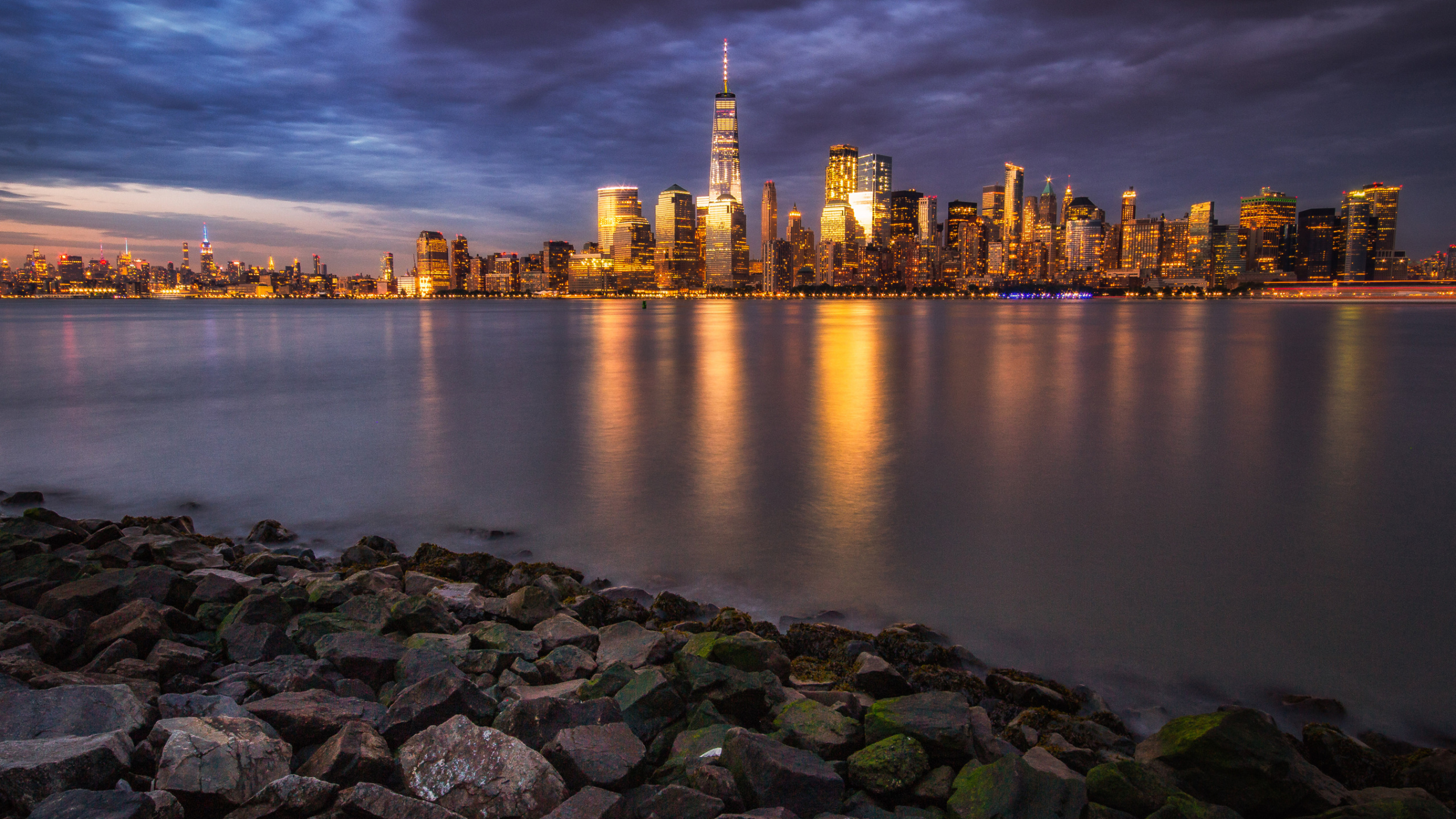 City Skyline Across Body of Water During Night Time. Wallpaper in 2560x1440 Resolution