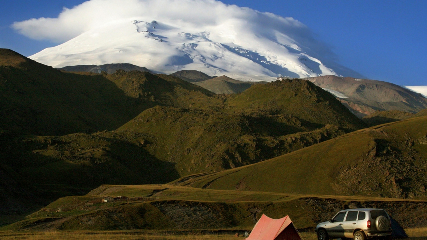 Tienda Roja en el Campo de Hierba Verde Cerca de la Montaña Bajo Nubes Blancas y Cielo Azul Durante el Día. Wallpaper in 1366x768 Resolution