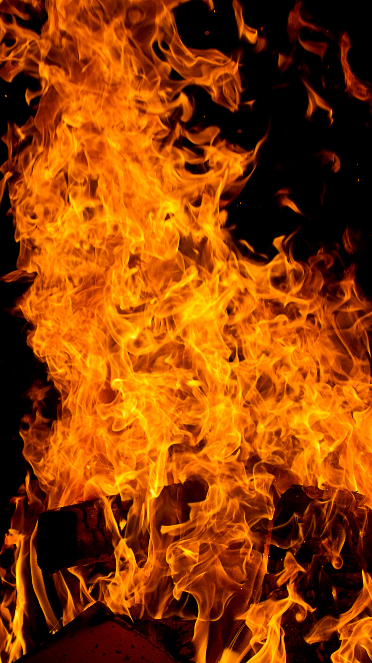 Gelbes Feuer Auf Schwarzem Hintergrund. Wallpaper in 750x1334 Resolution
