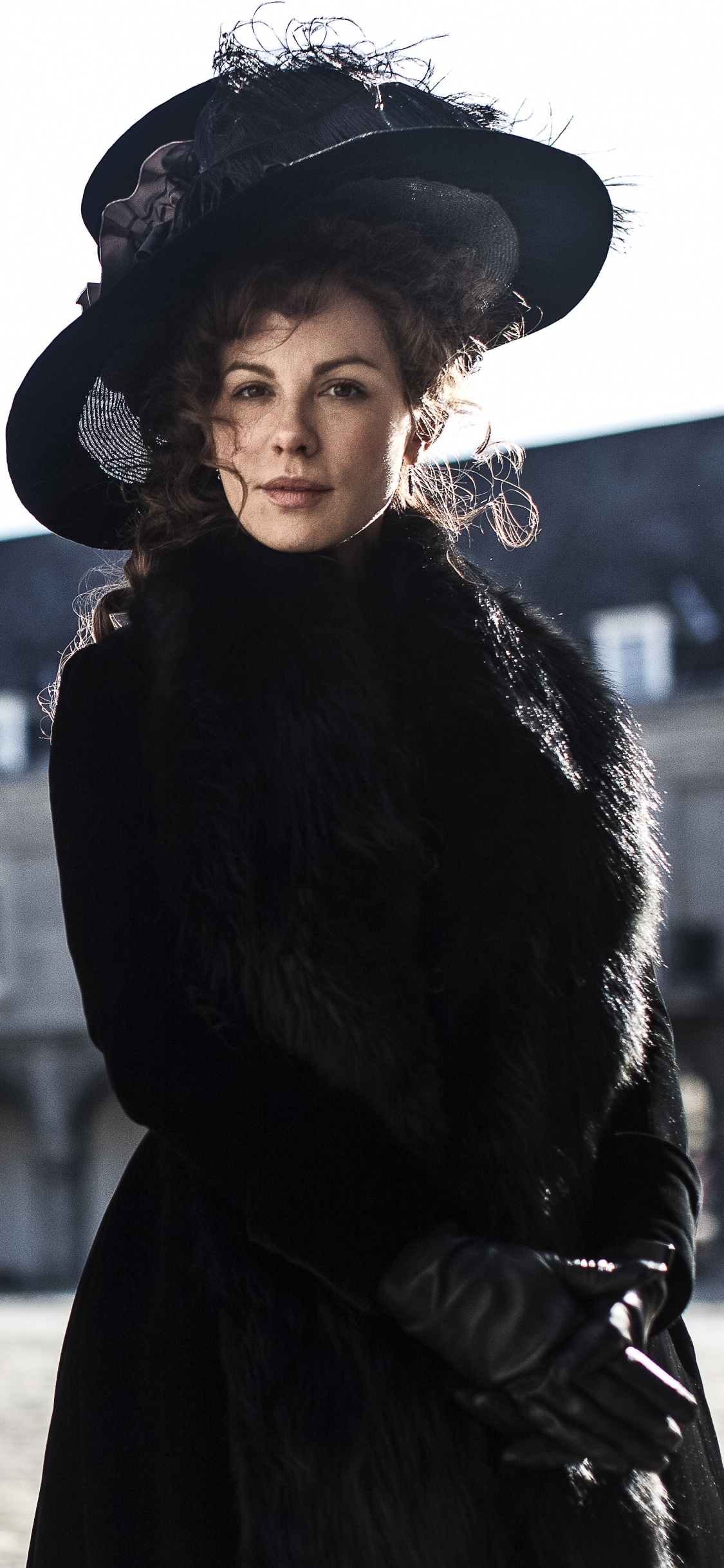 Femme en Manteau Noir et Chapeau Noir Debout Sur un Sol Couvert de Neige Pendant la Journée. Wallpaper in 1125x2436 Resolution