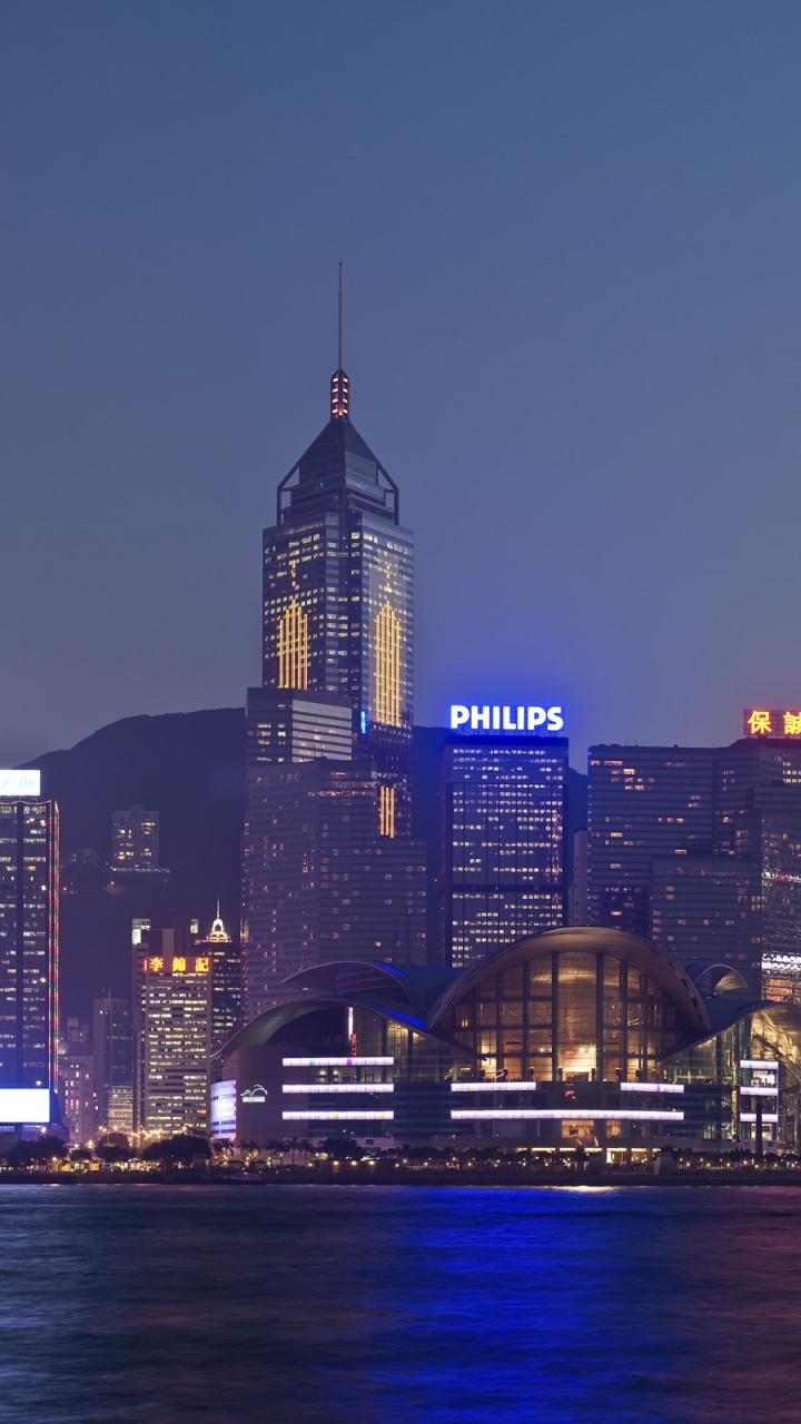 Skyline Der Stadt in Der Nähe Von Gewässern Während Der Nacht. Wallpaper in 720x1280 Resolution