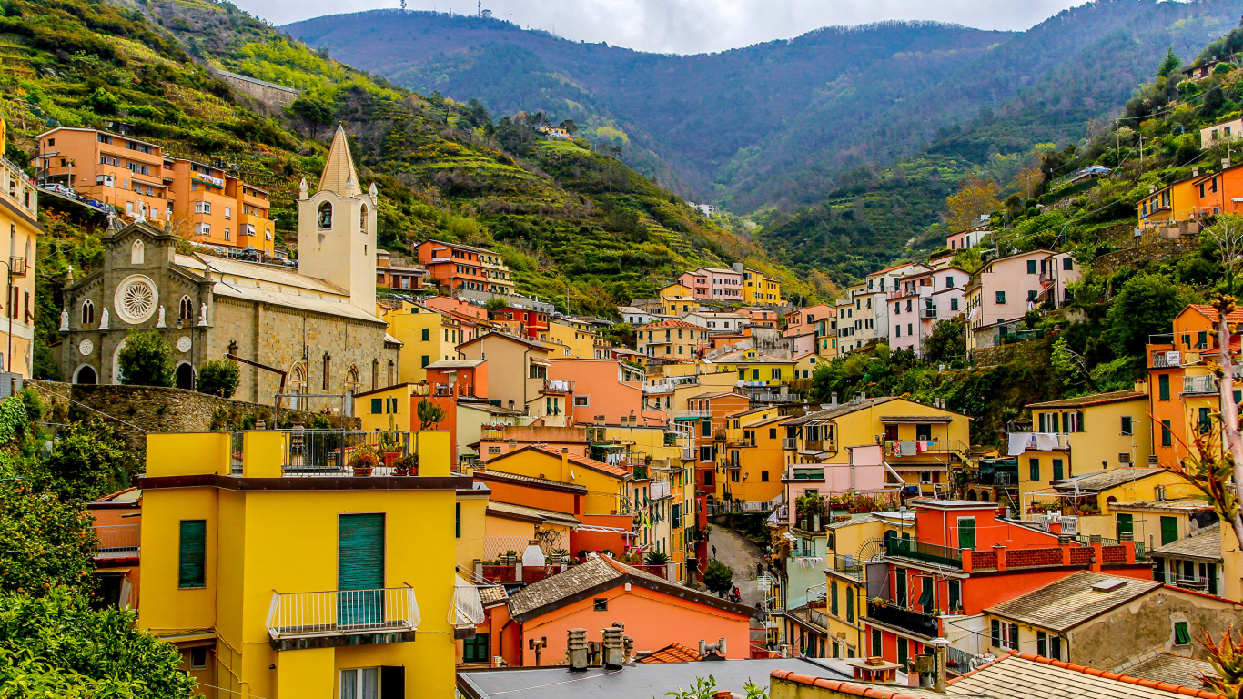 Yellow and Brown Concrete Houses Near Green Mountains During Daytime. Wallpaper in 1366x768 Resolution