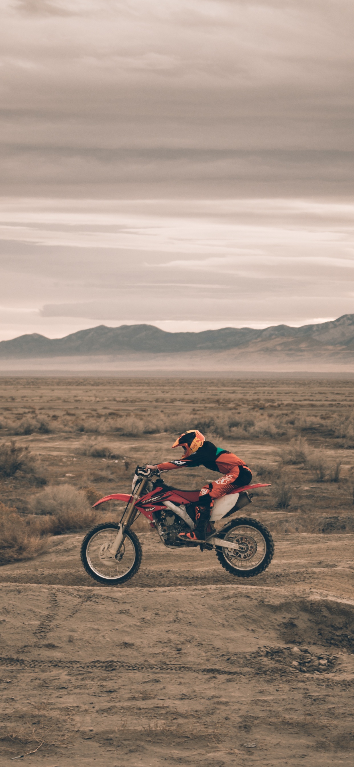 Man in Red Jacket Riding on Red Motorcycle on Brown Field During Daytime. Wallpaper in 1242x2688 Resolution