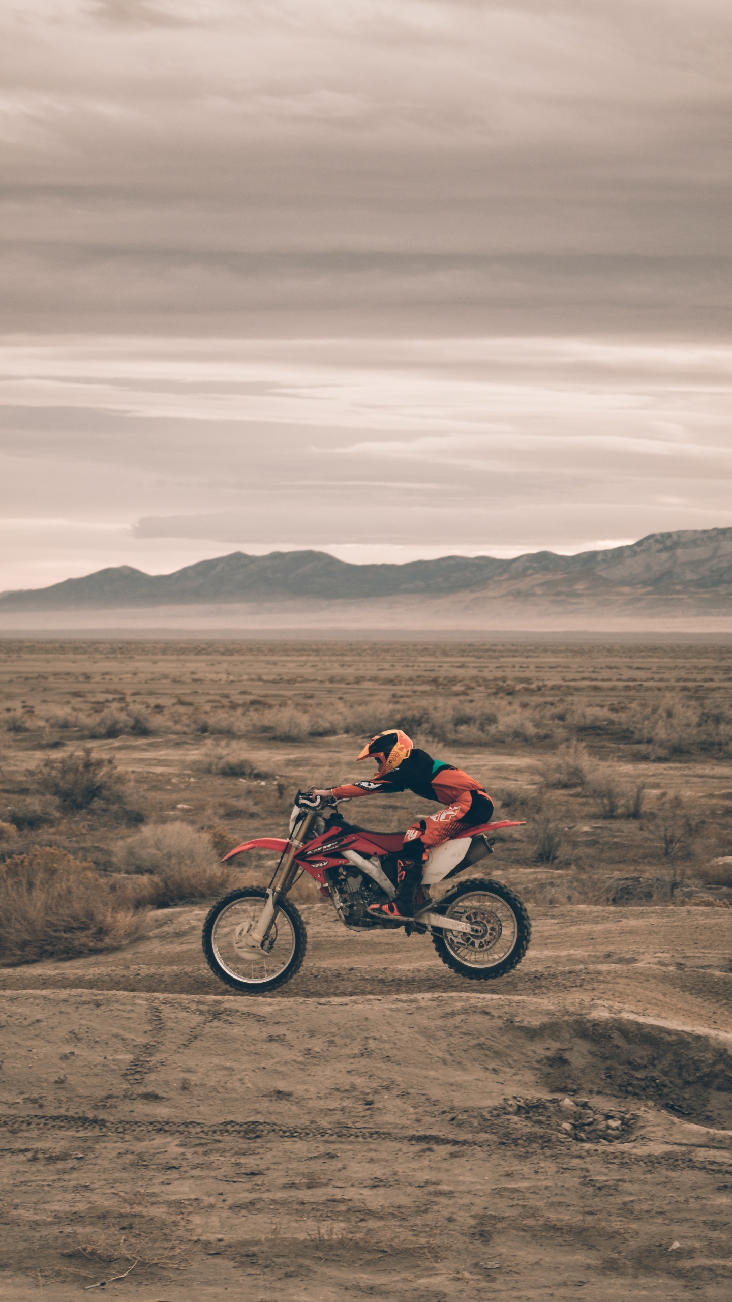 Man in Red Jacket Riding on Red Motorcycle on Brown Field During Daytime. Wallpaper in 1440x2560 Resolution