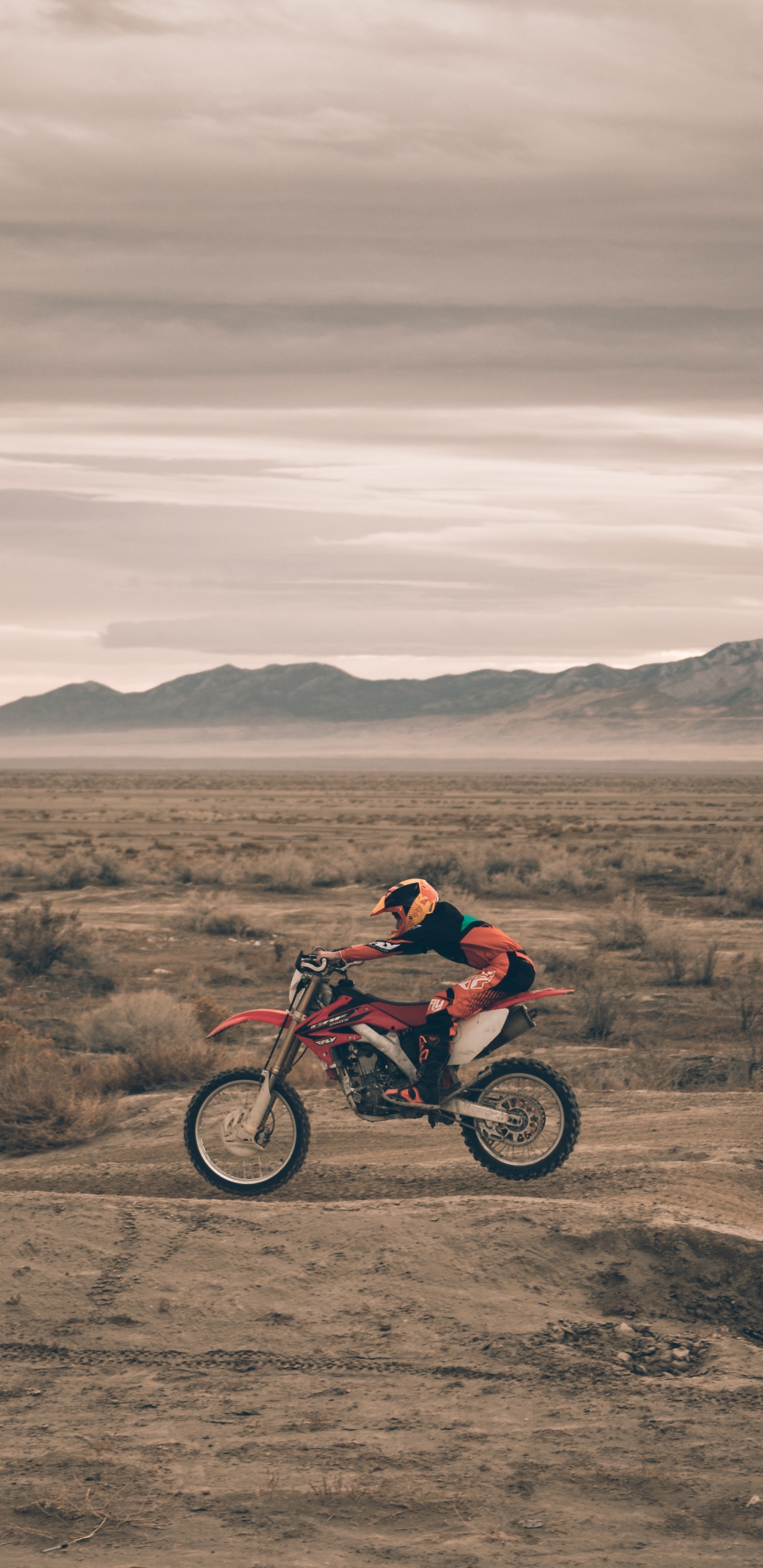 Hombre de Chaqueta Roja en Motocicleta Roja en Campo Marrón Durante el Día. Wallpaper in 1440x2960 Resolution