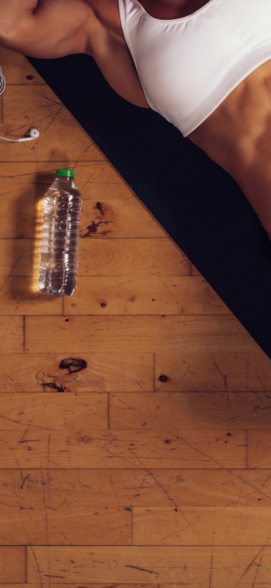 Person in Weißem Tanktop Und Schwarzen Shorts. Wallpaper in 1125x2436 Resolution