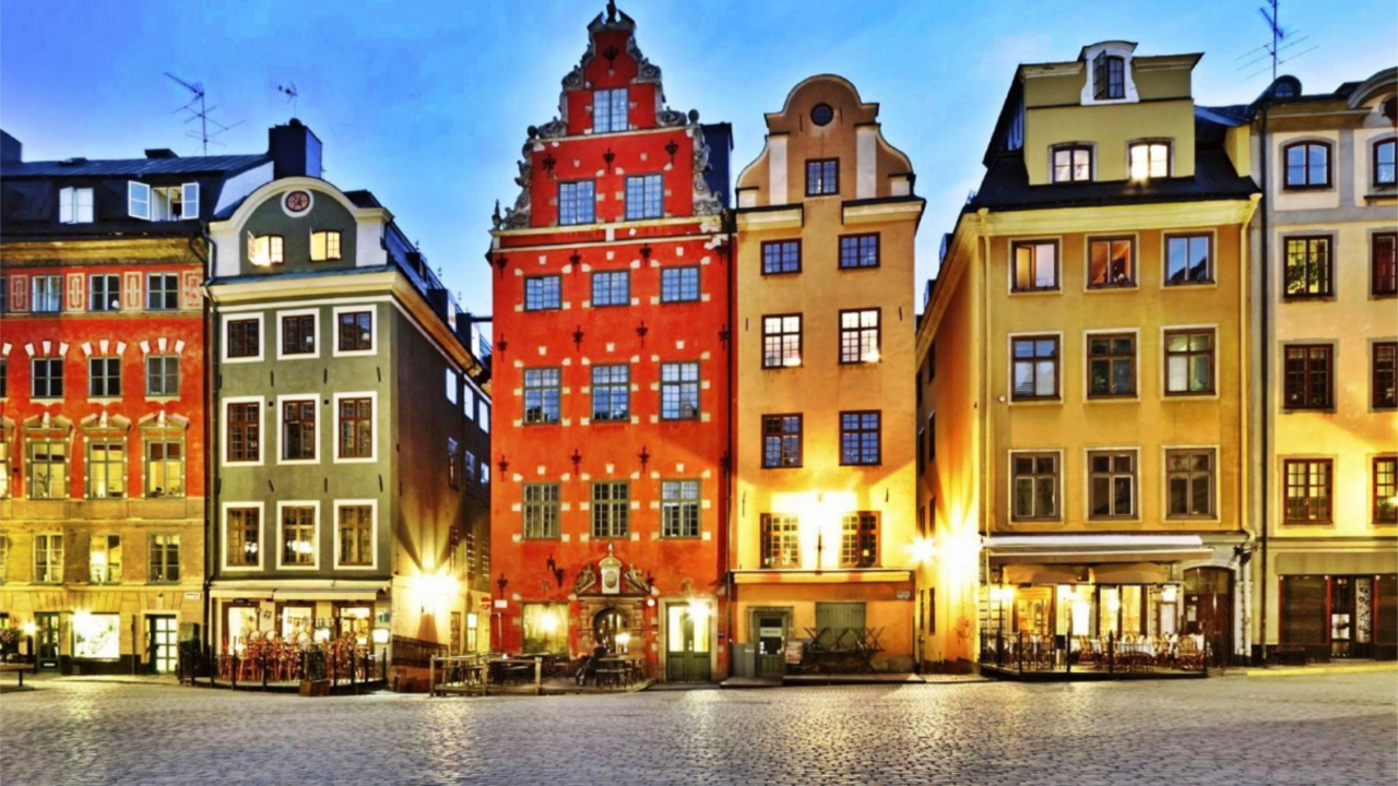 Gelbes Und Grünes Betongebäude in Der Nähe Eines Gewässers Während Der Nacht. Wallpaper in 1280x720 Resolution