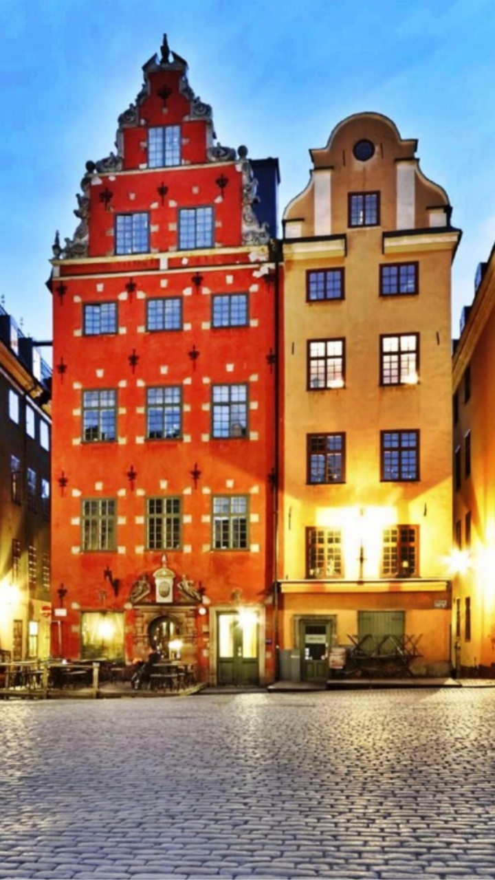 Gelbes Und Grünes Betongebäude in Der Nähe Eines Gewässers Während Der Nacht. Wallpaper in 720x1280 Resolution