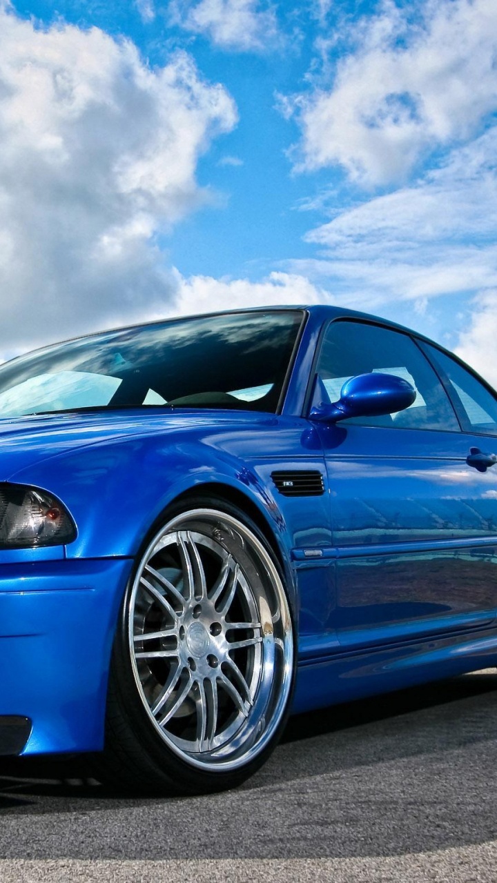 Coupé Bmw m 3 Bleu Sur Route Goudronnée Grise Sous Des Nuages Blancs et Ciel Bleu Pendant. Wallpaper in 720x1280 Resolution