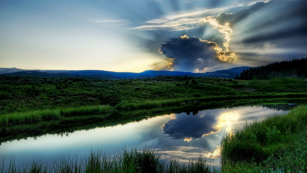 Green Grass Field Near Lake Under Cloudy Sky During Daytime. Wallpaper in 1280x720 Resolution