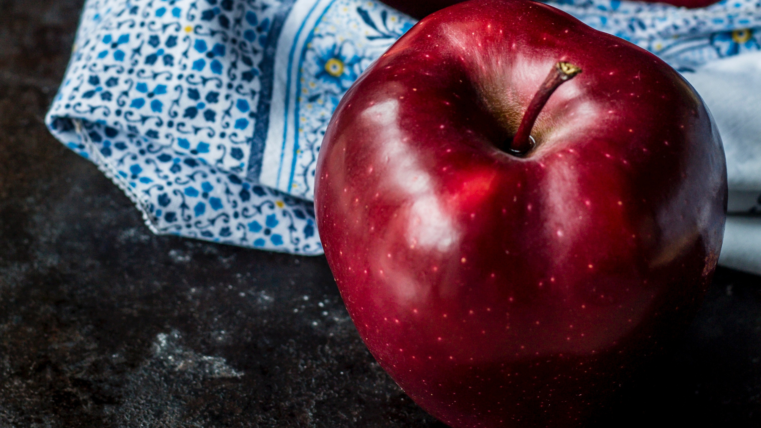 Red Apple on Blue and White Textile. Wallpaper in 2560x1440 Resolution