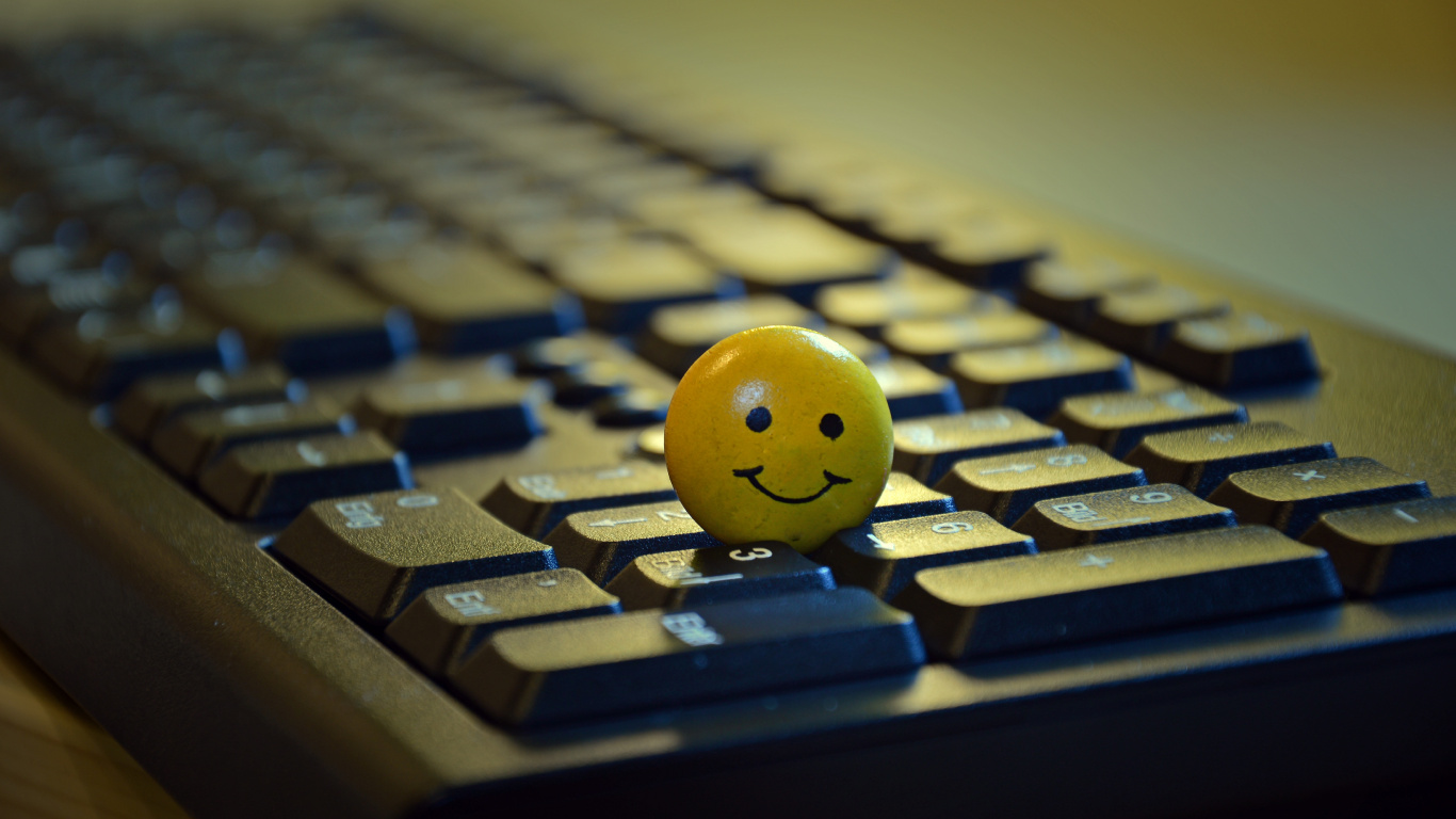 Yellow Smiley Ball on Black Computer Keyboard. Wallpaper in 1366x768 Resolution