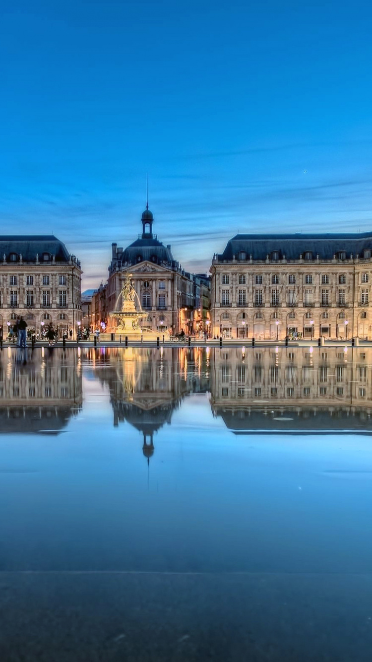 Bâtiment en Béton Brun Près D'un Plan D'eau Pendant la Journée. Wallpaper in 750x1334 Resolution