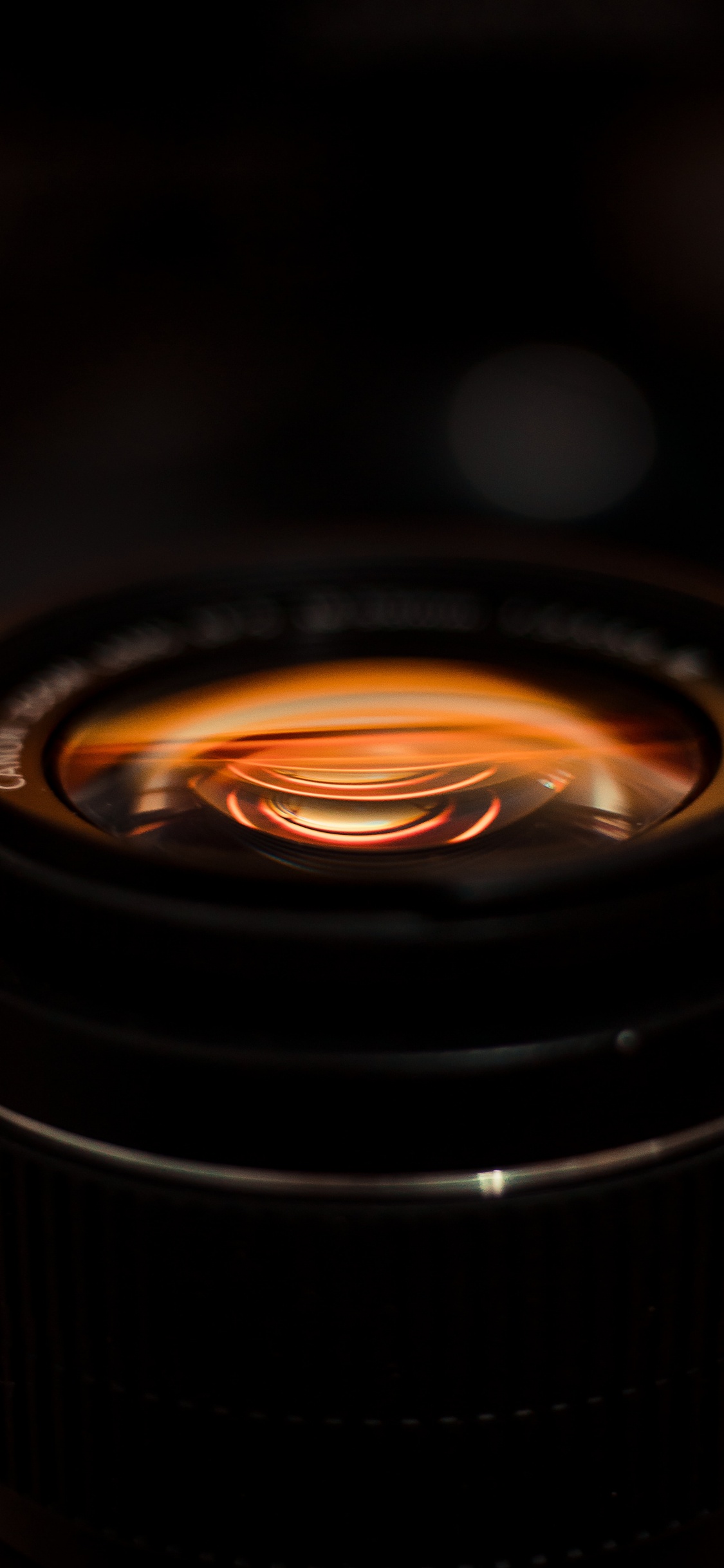 Schwarzes Kameraobjektiv Mit Orangefarbenem Licht. Wallpaper in 1125x2436 Resolution