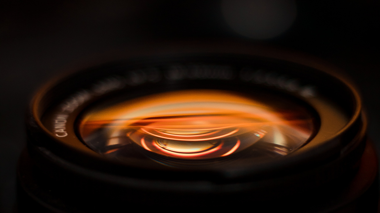 Black Camera Lens With Orange Light. Wallpaper in 1280x720 Resolution