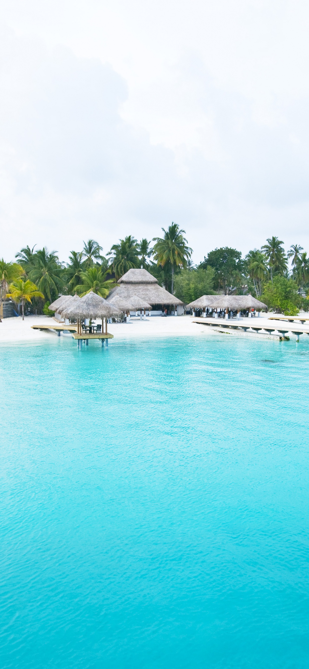 White and Brown Wooden Beach Houses Near Body of Water During Daytime. Wallpaper in 1242x2688 Resolution
