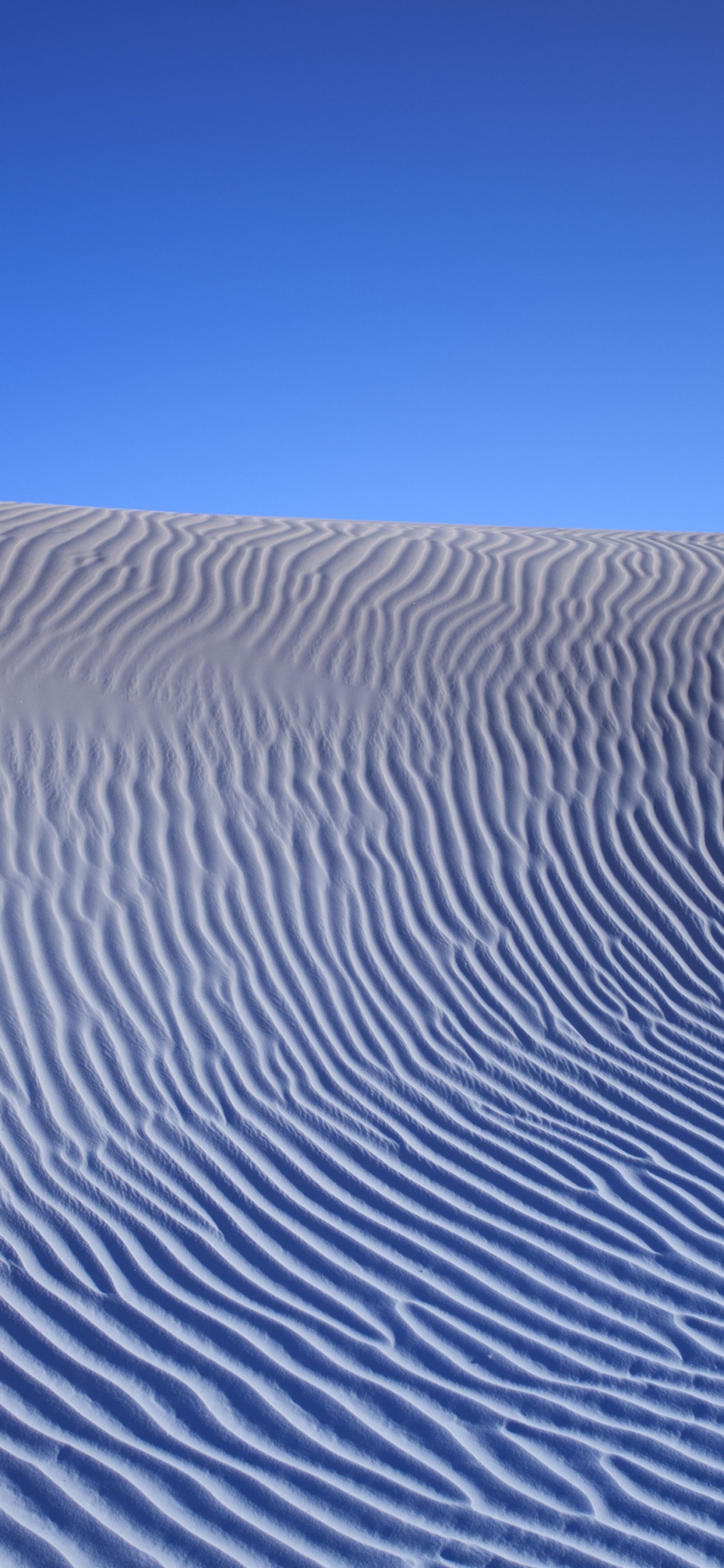 Sable Blanc Sous Ciel Bleu Pendant la Journée. Wallpaper in 1125x2436 Resolution