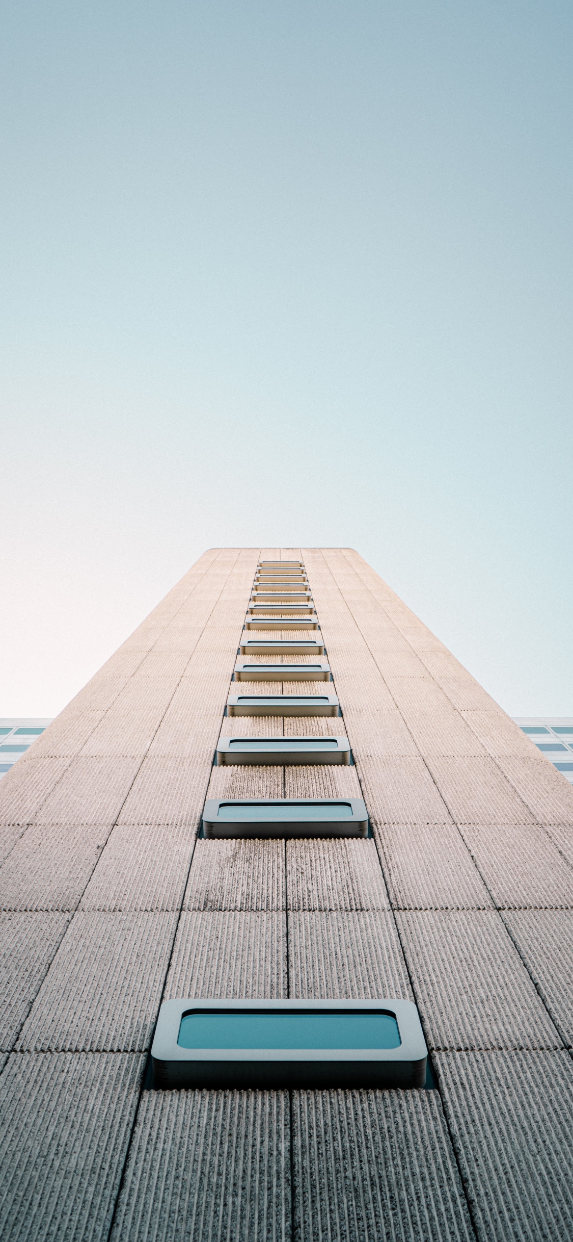Gray Concrete Building Under Blue Sky During Daytime. Wallpaper in 1125x2436 Resolution