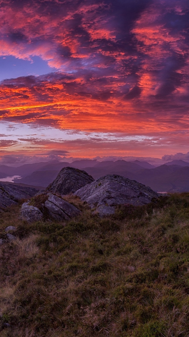 Grüne Wiese in Der Nähe Von Berg Unter Orangefarbenem Und Blauem Himmel. Wallpaper in 720x1280 Resolution