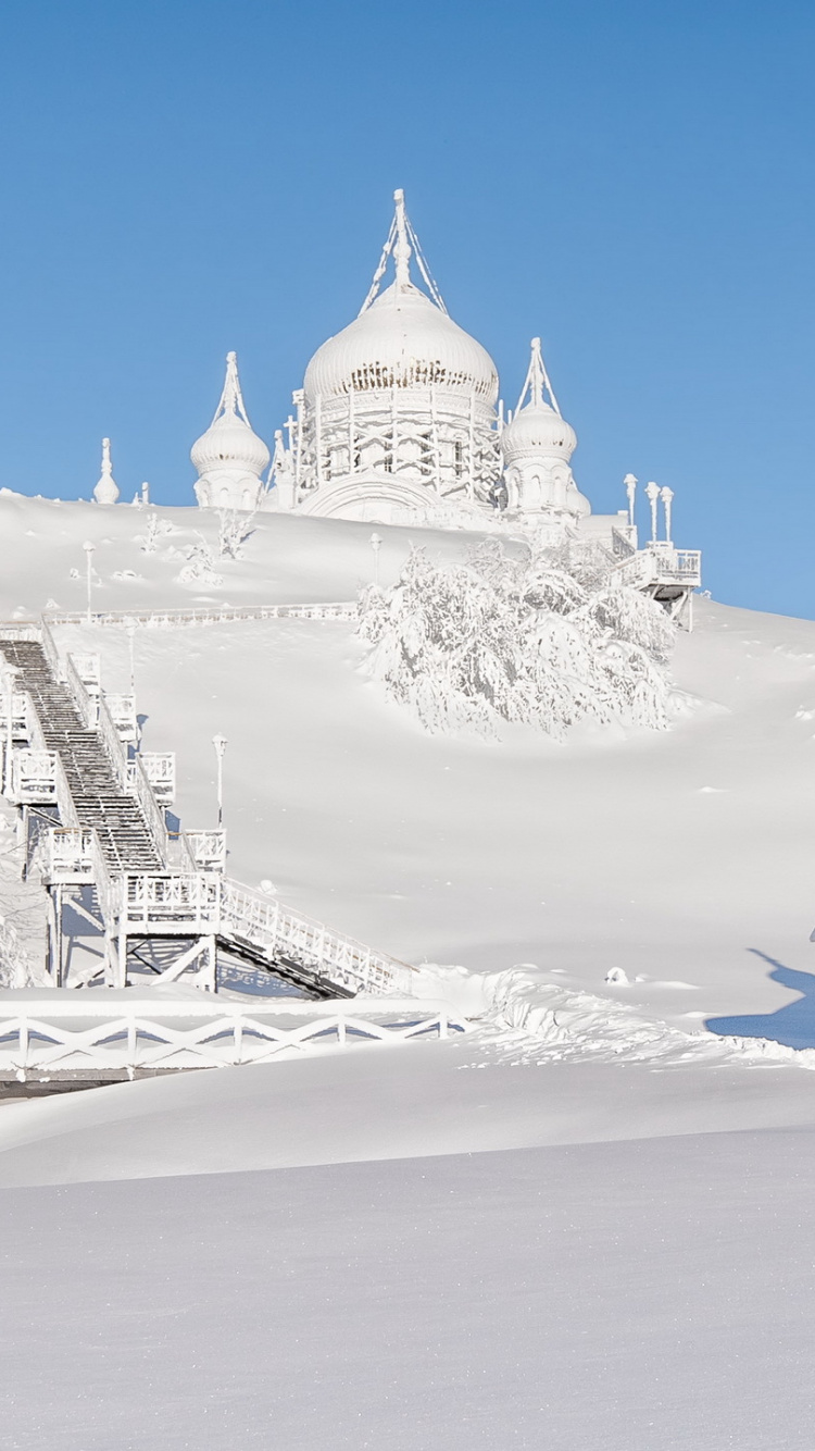 White and Brown Concrete Building on Snow Covered Ground Under Blue Sky During Daytime. Wallpaper in 750x1334 Resolution