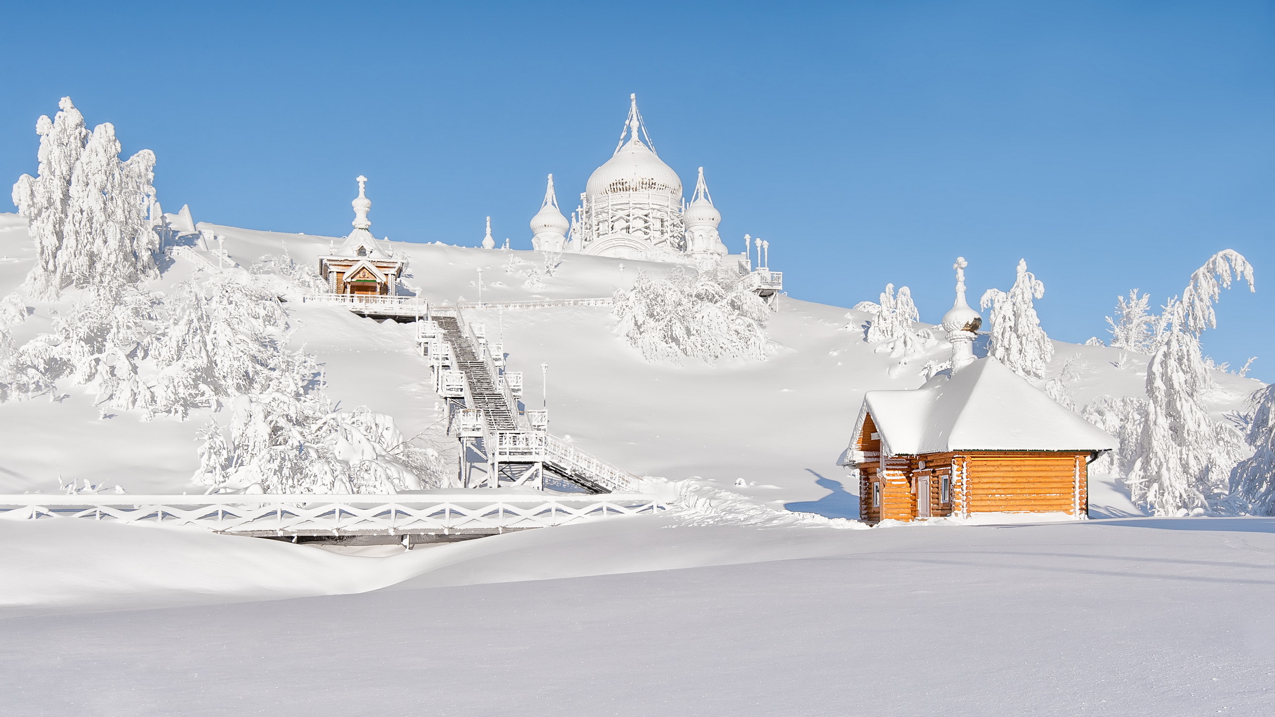 Edificio de Hormigón Blanco y Marrón Sobre Suelo Cubierto de Nieve Bajo un Cielo Azul Durante el Día. Wallpaper in 2560x1440 Resolution