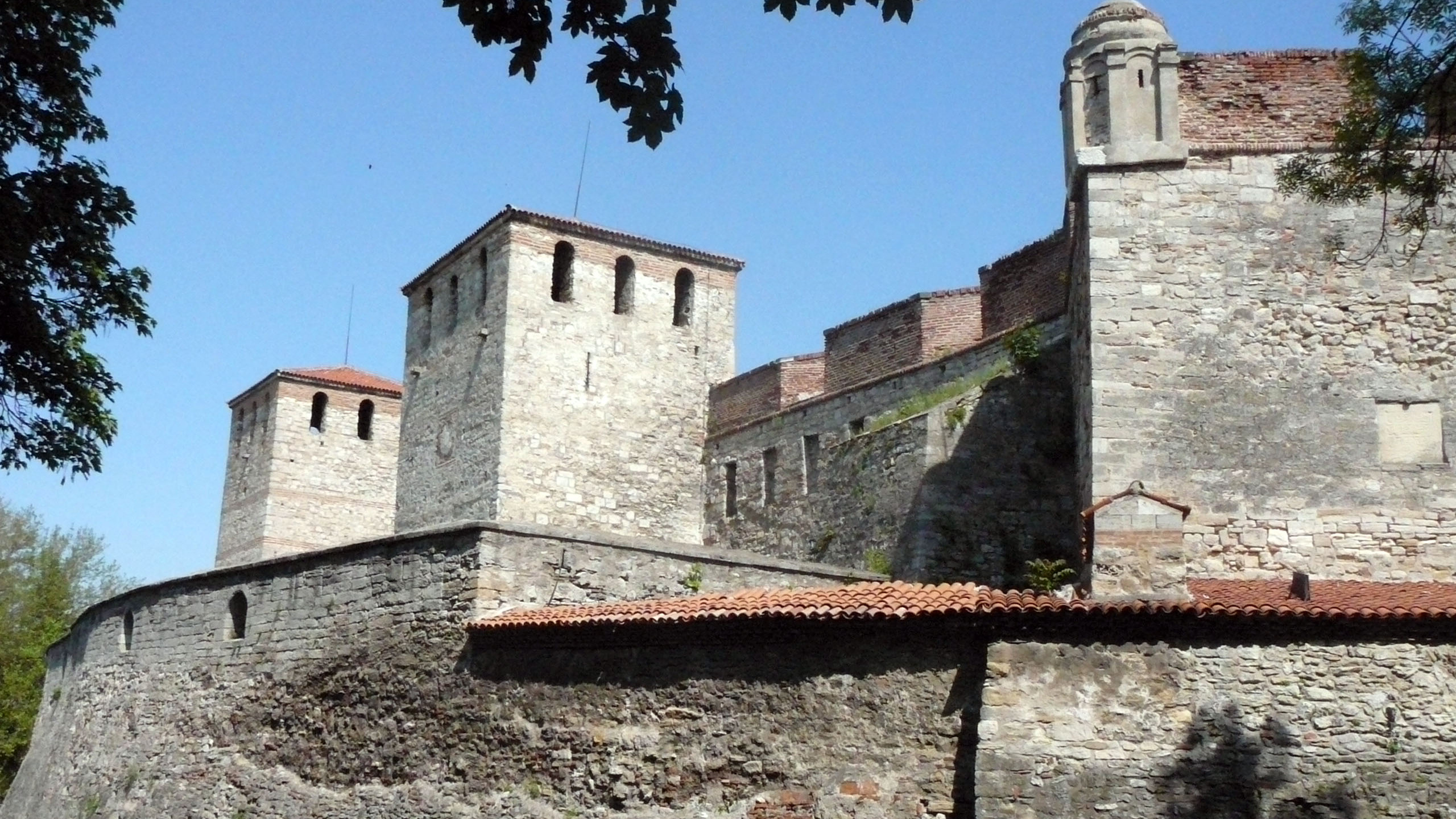 Brown Brick Building Near Green Trees During Daytime. Wallpaper in 2560x1440 Resolution