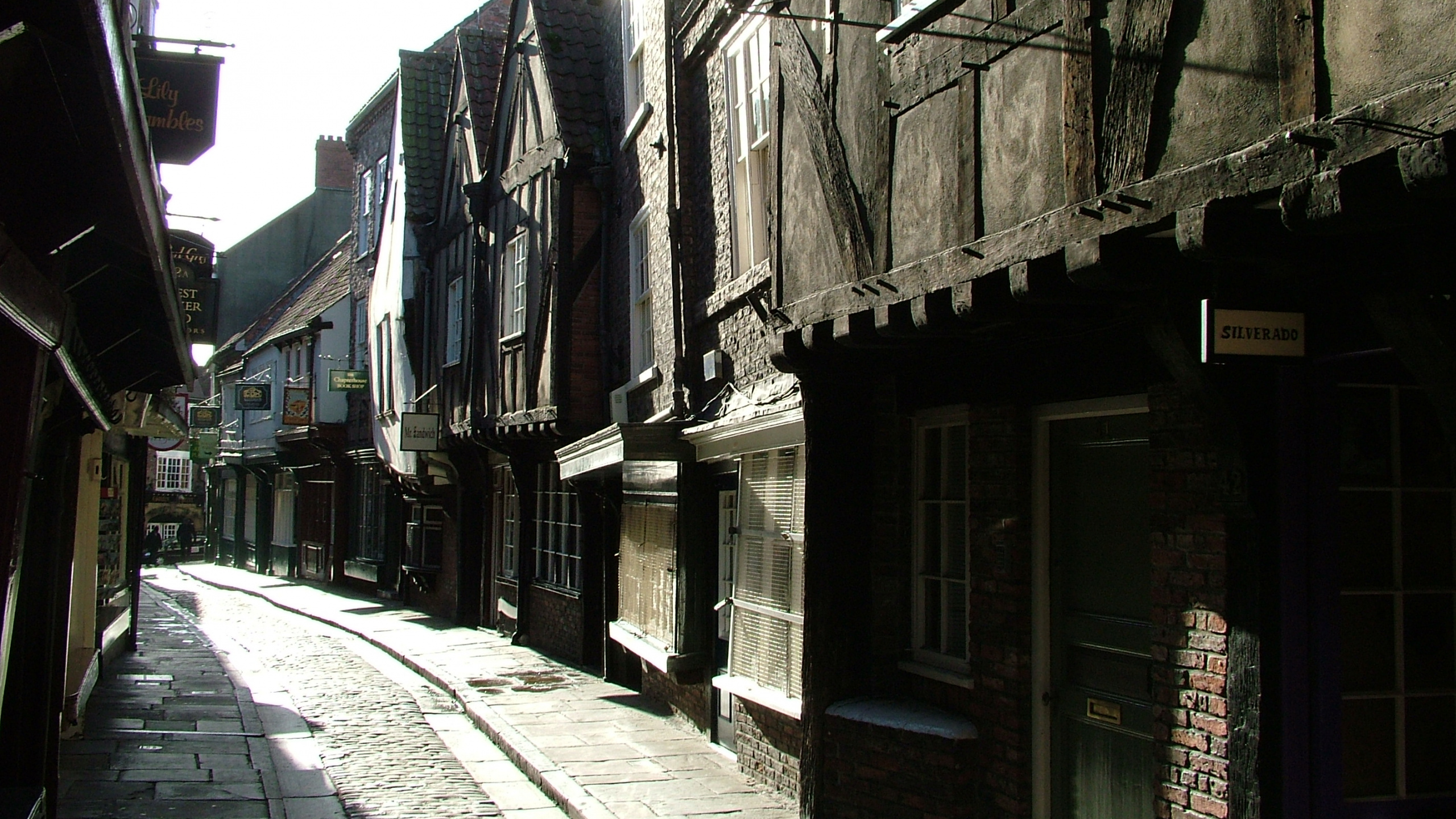 Graue Betonstraße Zwischen Den Häusern Tagsüber. Wallpaper in 2560x1440 Resolution