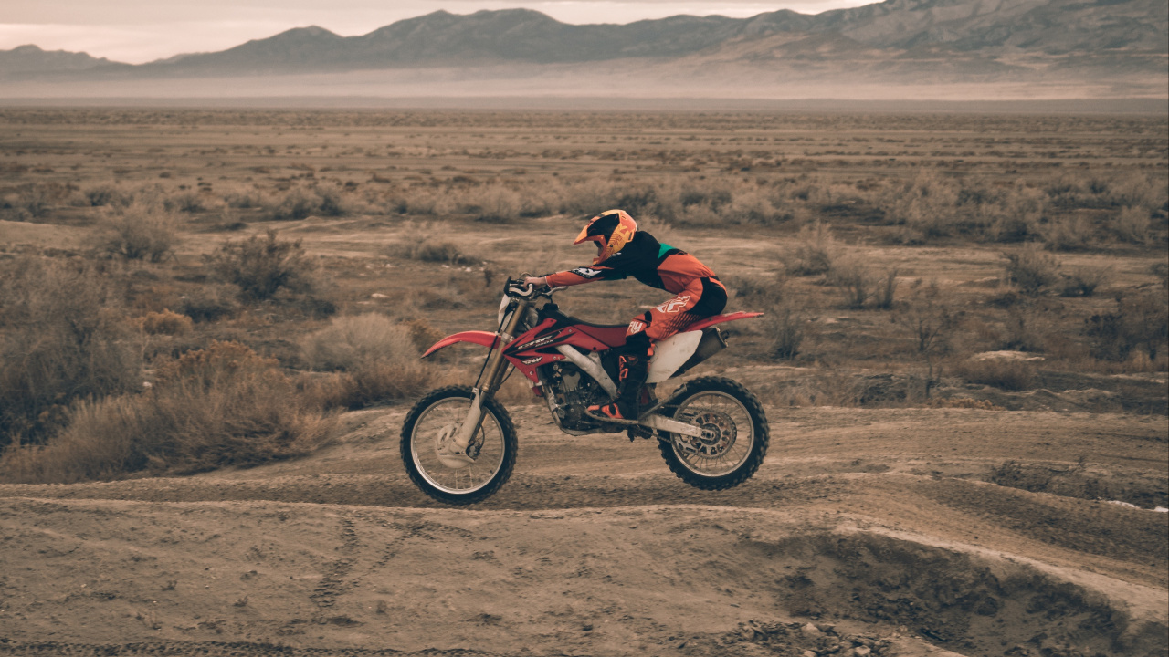 Hombre de Chaqueta Roja Cabalgando Sobre Motocross Dirt Bike. Wallpaper in 1280x720 Resolution