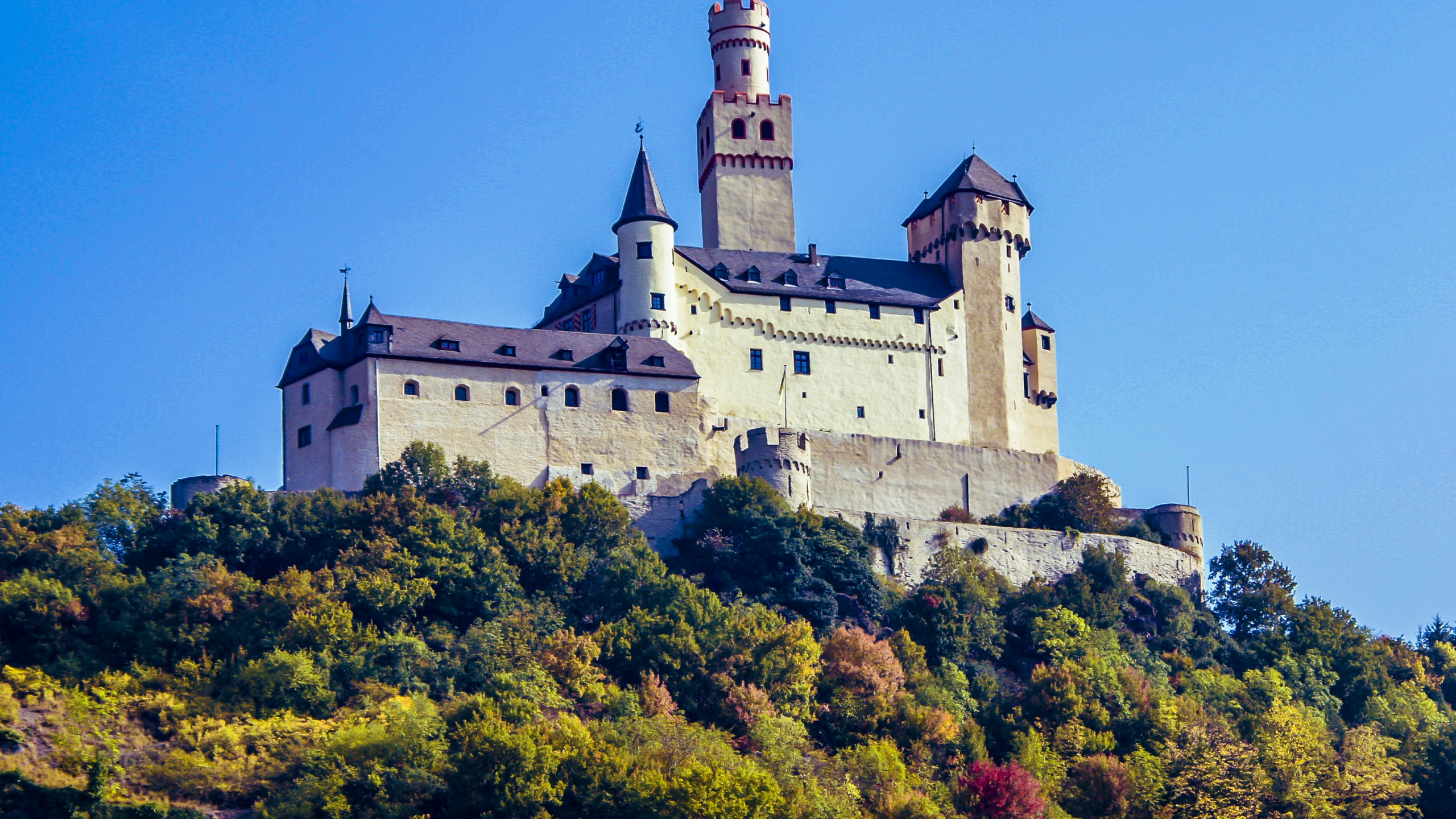 White and Gray Concrete Castle on Top of Green Mountain During Daytime. Wallpaper in 2560x1440 Resolution