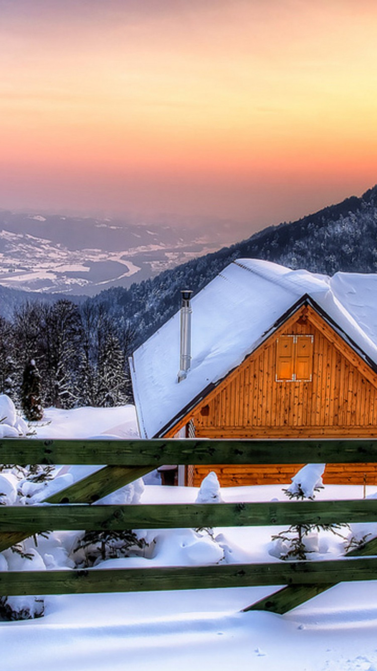 Braunes Holzhaus Auf Schneebedecktem Boden in Der Nähe Von Schneebedeckten Bergen Tagsüber During. Wallpaper in 750x1334 Resolution