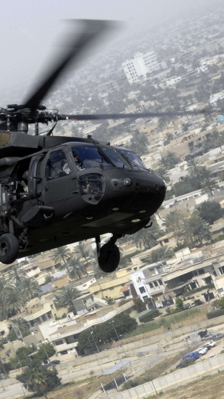 Hélicoptère Noir et Gris Survolant la Ville Pendant la Journée. Wallpaper in 720x1280 Resolution