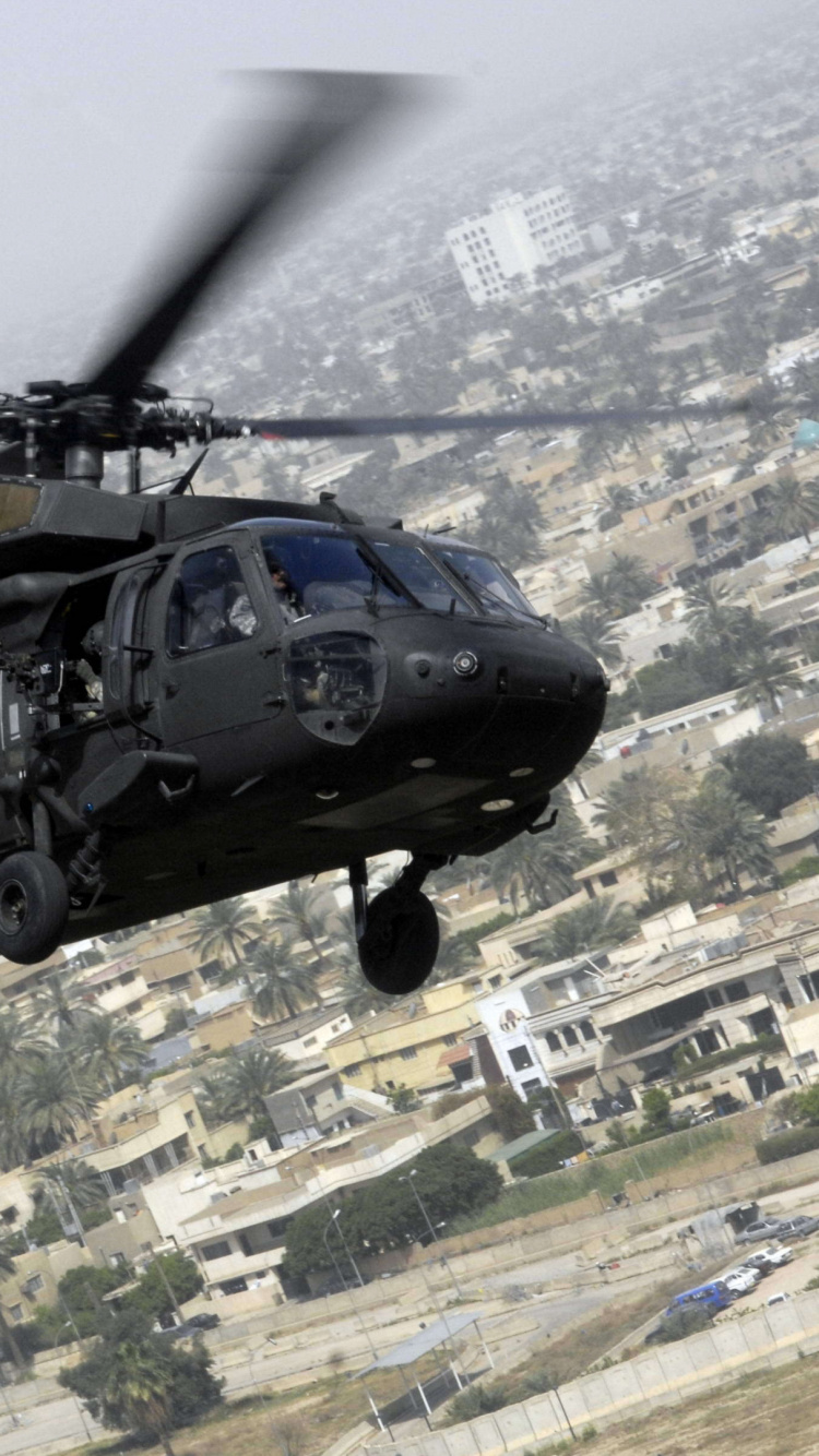 Hélicoptère Noir et Gris Survolant la Ville Pendant la Journée. Wallpaper in 750x1334 Resolution