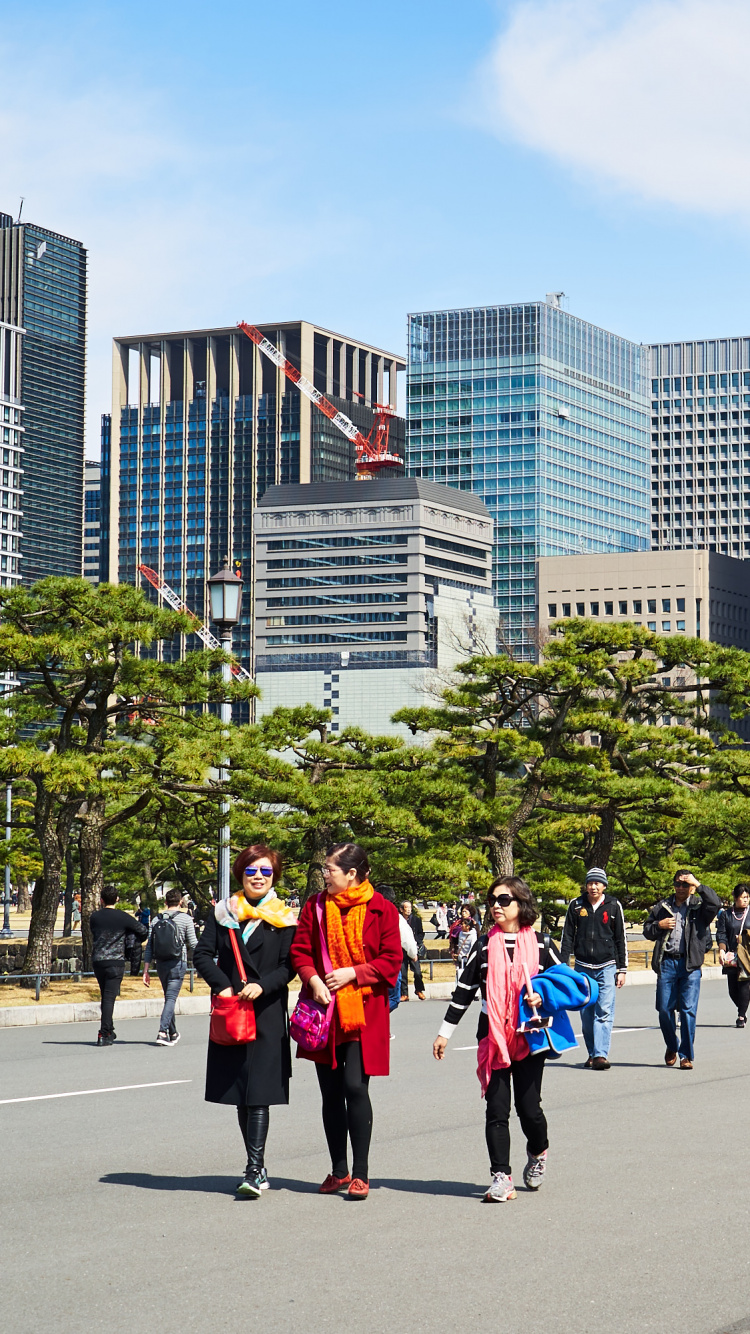 People Walking on Gray Concrete Road Near High Rise Buildings During Daytime. Wallpaper in 750x1334 Resolution