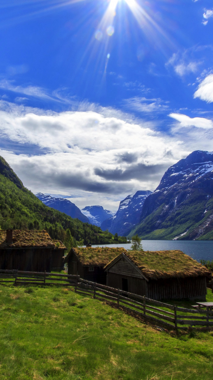 Brown Wooden House on Green Grass Field Near Mountain Under Blue Sky During Daytime. Wallpaper in 750x1334 Resolution