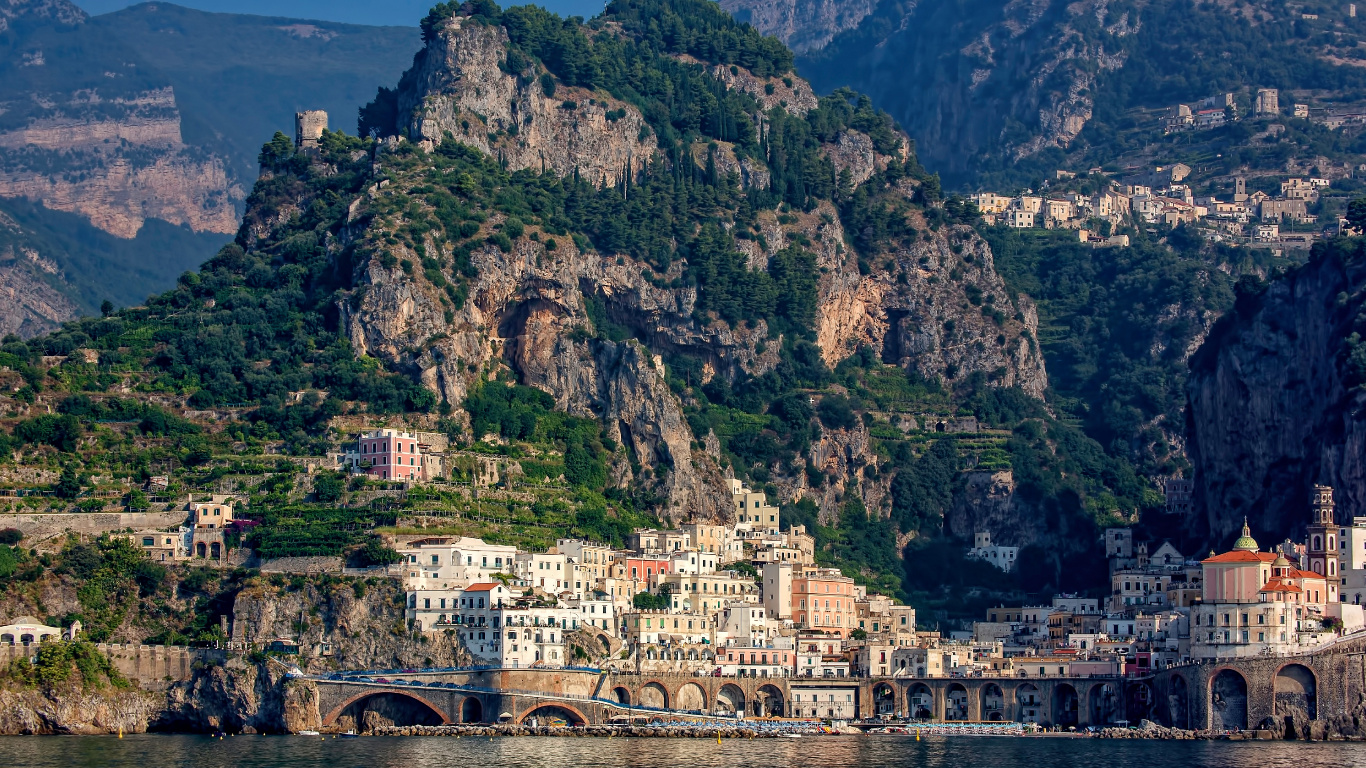 Weißes Und Braunes Betongebäude in Der Nähe Des Grünen Berges Tagsüber. Wallpaper in 1366x768 Resolution