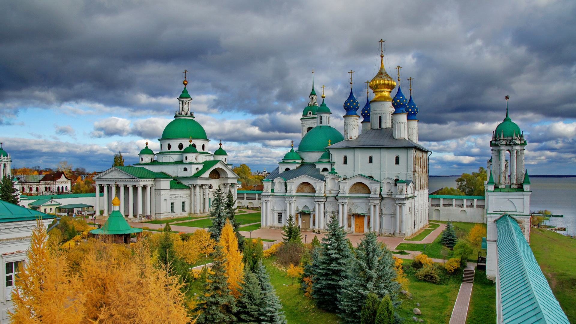 Edificio de Hormigón Blanco y Marrón Cerca de Árboles Verdes Bajo Nubes Blancas Durante el Día. Wallpaper in 1920x1080 Resolution
