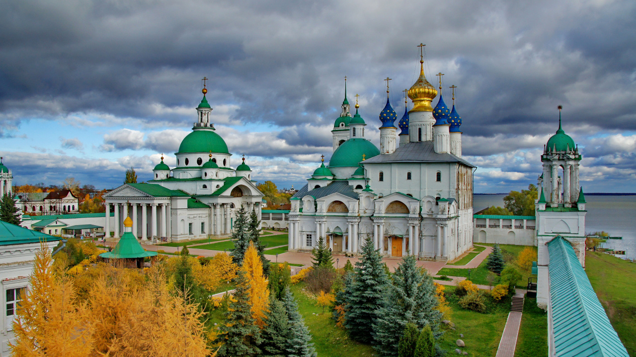 White and Brown Concrete Building Near Green Trees Under White Clouds During Daytime. Wallpaper in 1280x720 Resolution