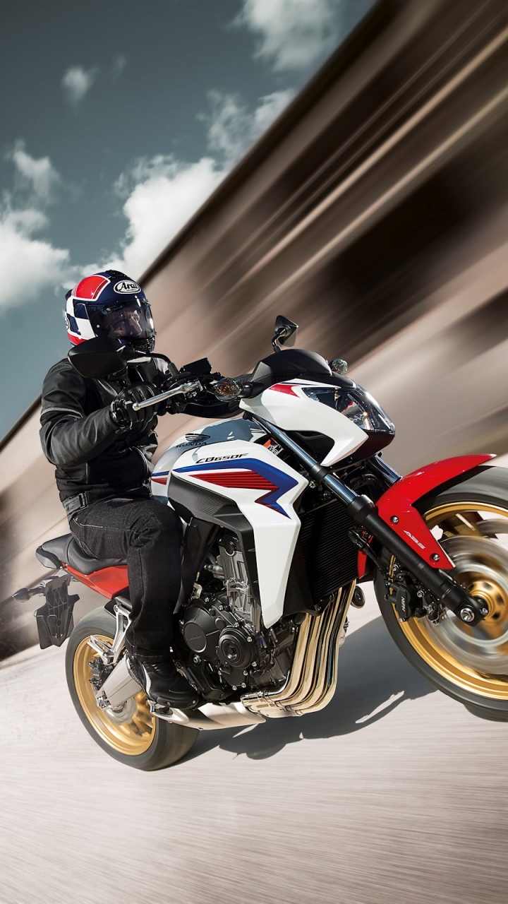 Man in Black and White Motorcycle Suit Riding Orange and Black Sports Bike. Wallpaper in 720x1280 Resolution