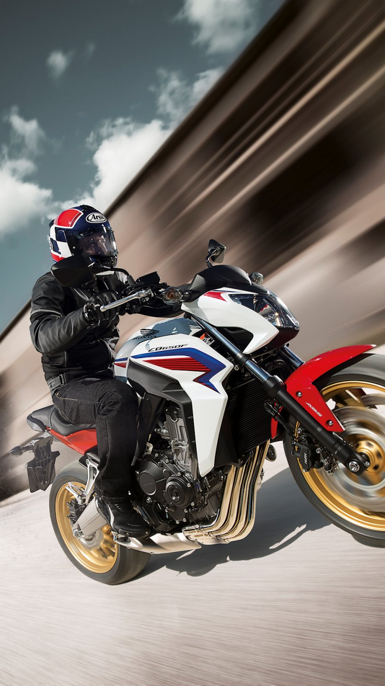 Man in Black and White Motorcycle Suit Riding Orange and Black Sports Bike. Wallpaper in 750x1334 Resolution