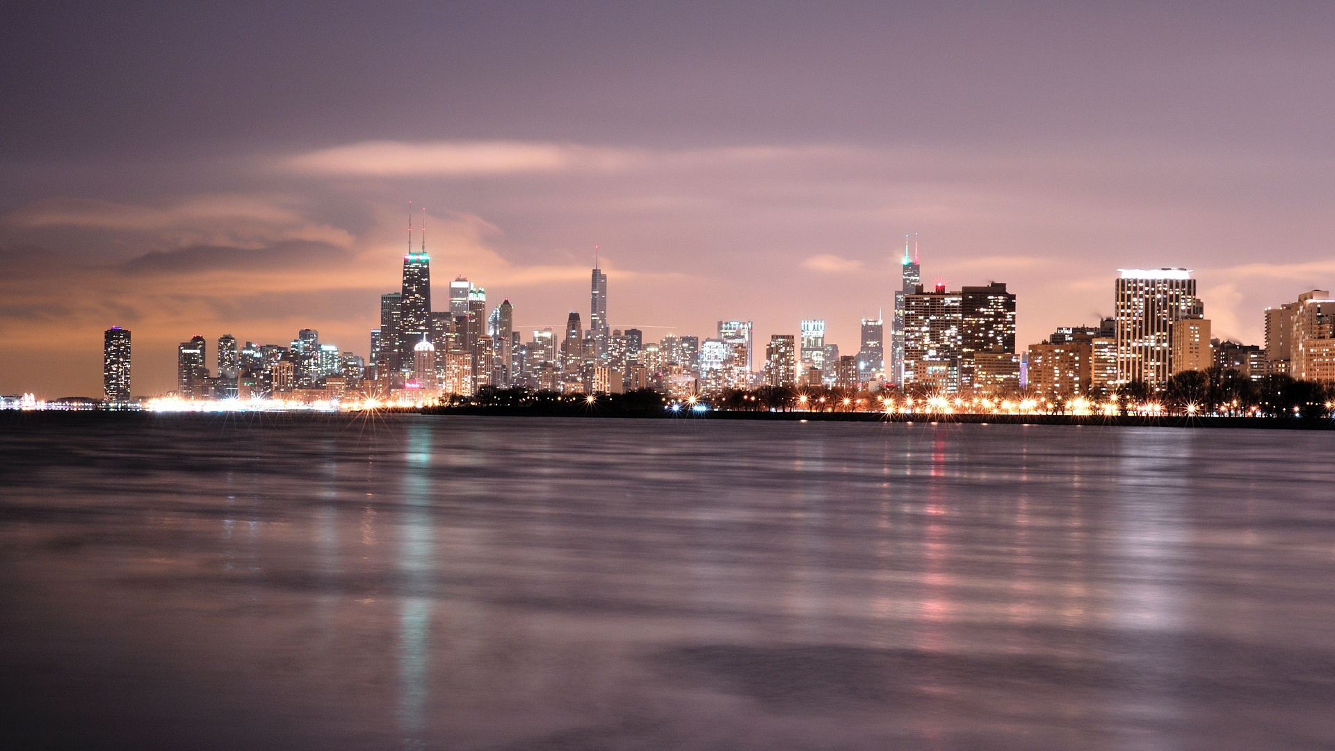 Skyline Der Stadt Über Gewässer Während Der Nacht. Wallpaper in 1920x1080 Resolution
