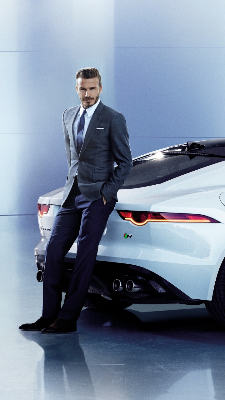 Hombre de Traje Negro de Pie Junto a Porsche 911 Coupe Blanco. Wallpaper in 720x1280 Resolution