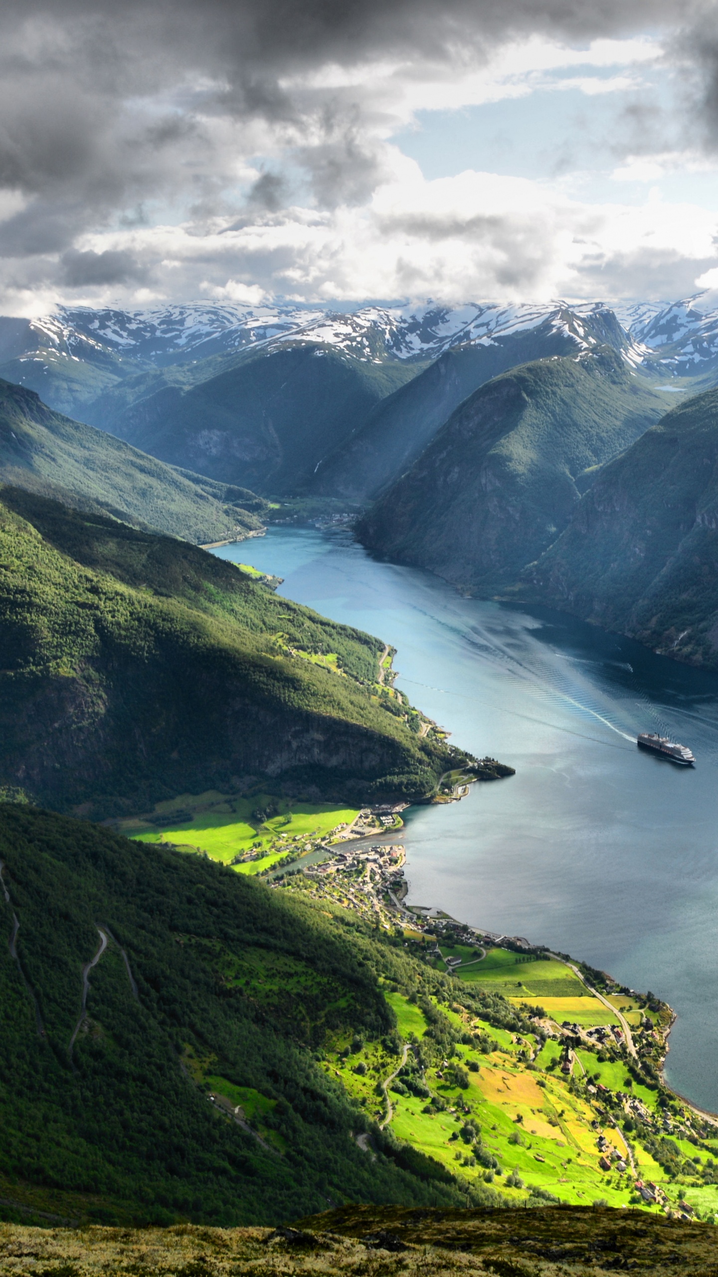Green Mountains Near Body of Water Under White Clouds During Daytime. Wallpaper in 1440x2560 Resolution